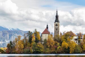 slovenia-historic-castle-surrounded-by-green-trees-near-lake-white-clouds-bled-slovenia